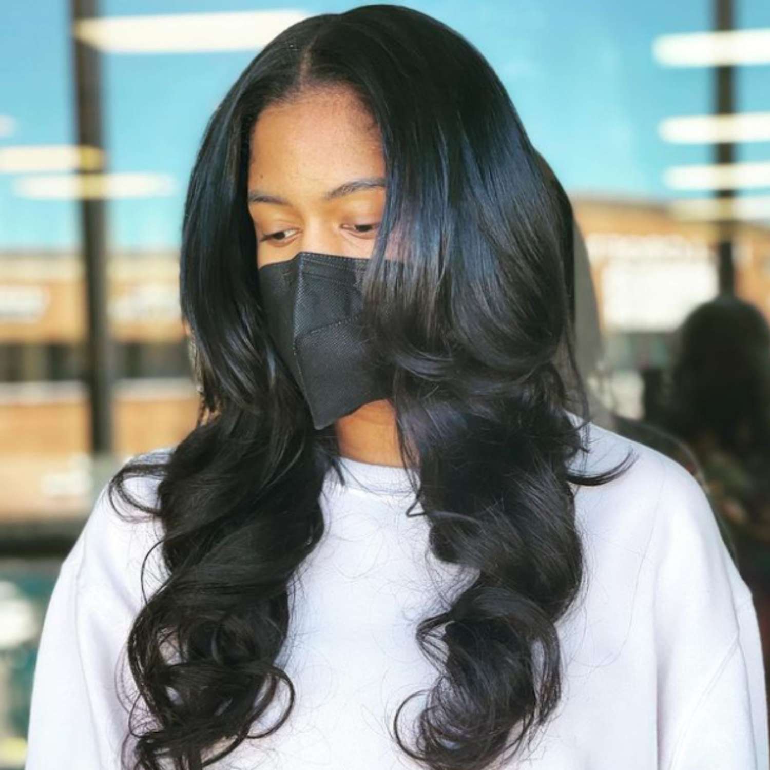 A woman with deep black hair in barrel waves