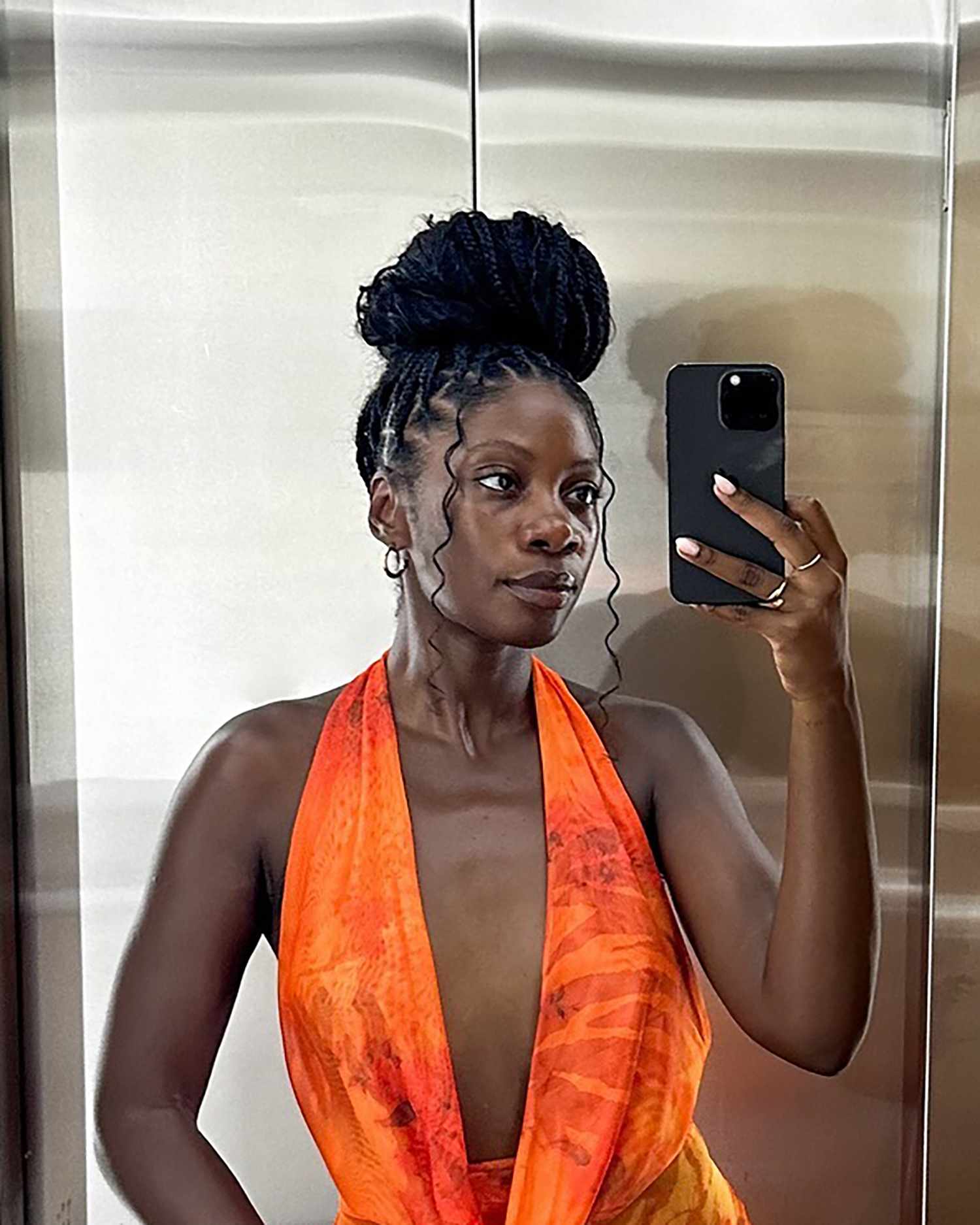 Byrdie social editor Jasmine Phillips with her braids piled into a top knot