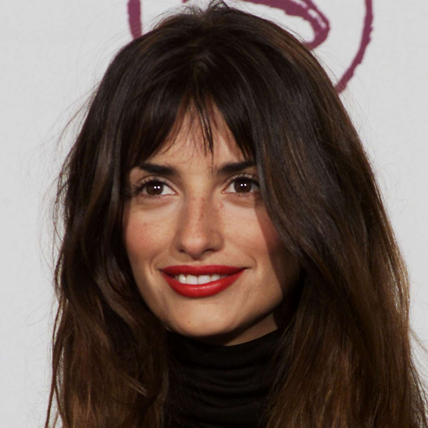 Penelope Cruz attends the Latin Grammy Awards wearing a bright red lip and french bangs