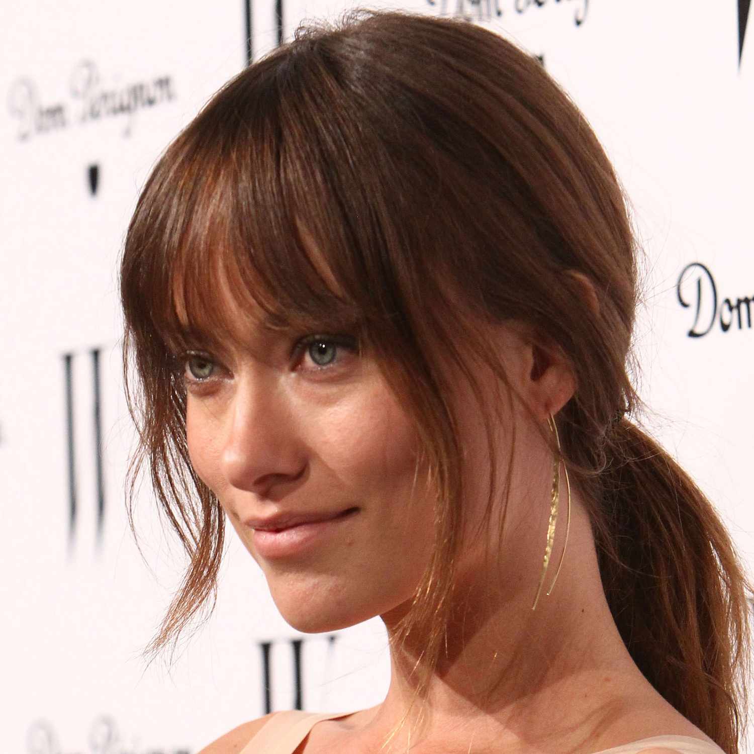 Olivia Wilde at a W Magazine event in LA with french bangs and a low ponytail