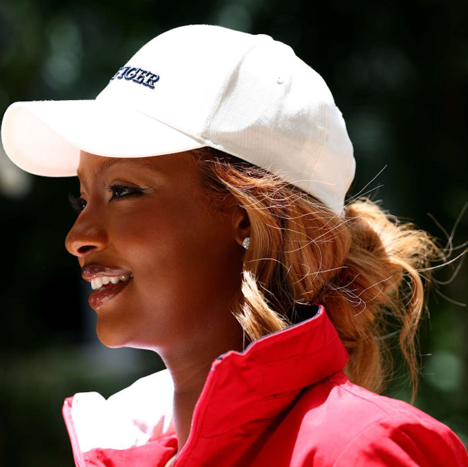 Justine Skye at the F1 Grand Prix of Miami wearing a white baseball cap with a messy bun